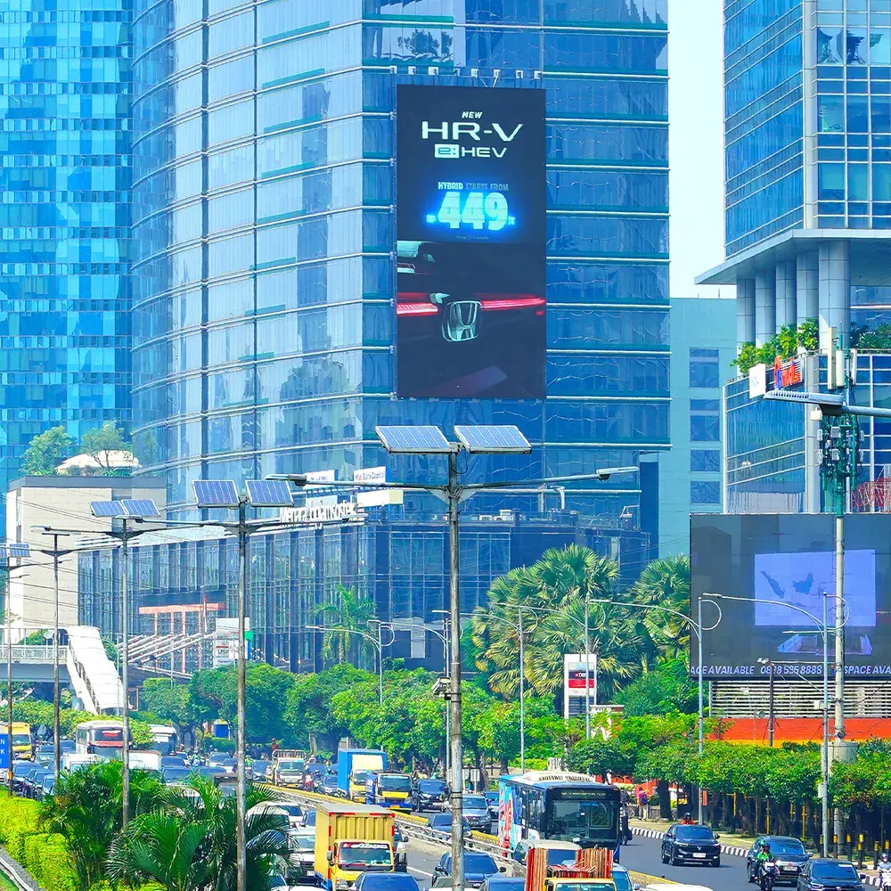 Tall portrait LED Jamsostek screen showing Honda artwork among office towers on Jl. Gatot Subroto
