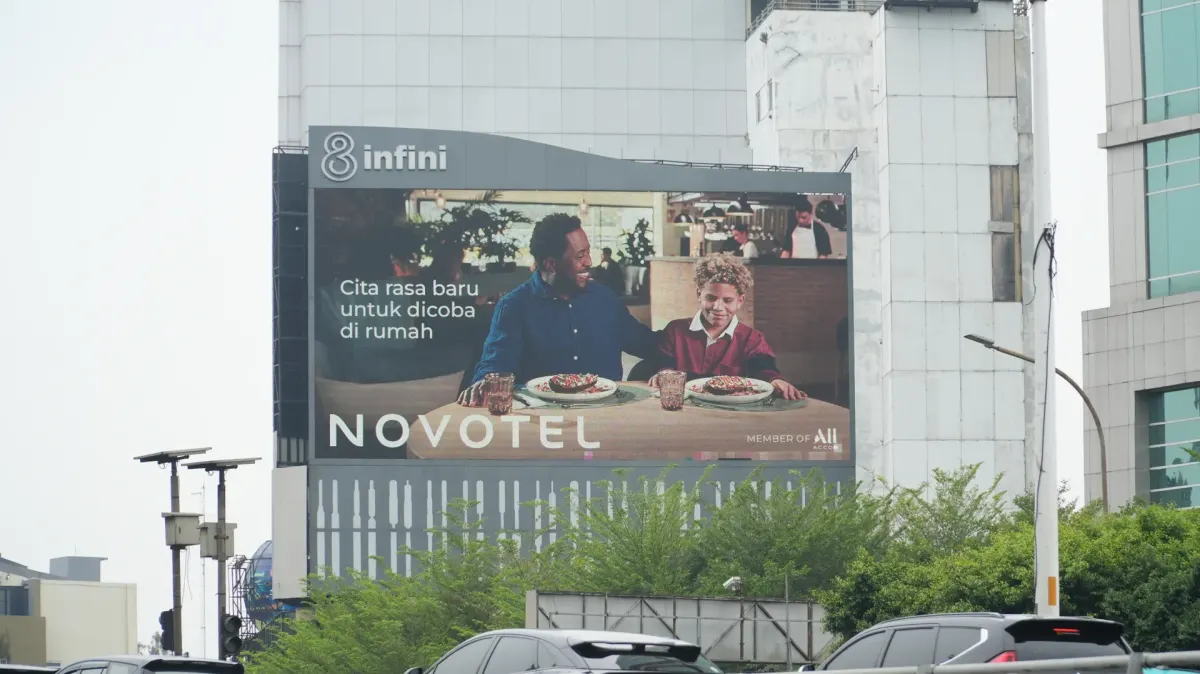 LED Slipi videotron on a building side on Jl. Letjen S. Parman, West Jakarta, showing an ad of two people at a dining table