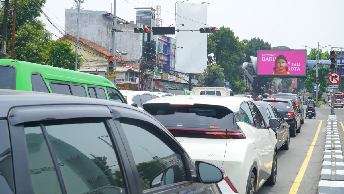 Antrean mobil dan angkot hijau di lampu merah kawasan Warung Jambu Bogor, dengan LED videotron 8infini di jembatan penyeberangan di kejauhan