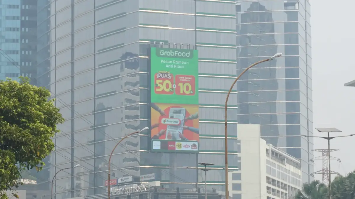 LED videotron potret berukuran besar di fasad gedung tinggi Jl. Gatot Subroto, Jakarta, di atas Menara Jamsostek