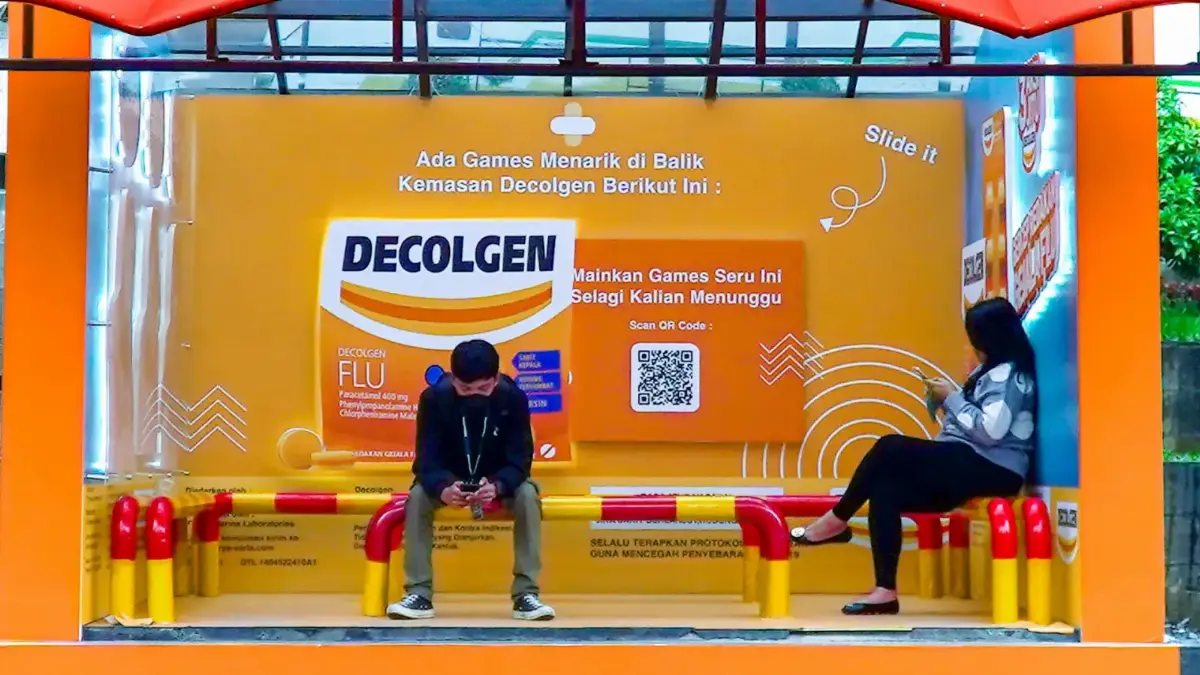 Decolgen-themed bus shelter with a board inviting people waiting for the bus to scan a QR code and play a game