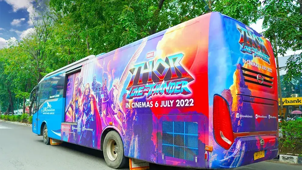 Bus Transjabodetabek dengan wrap kampanye film Thor dari Disney melaju di jalan Jakarta
