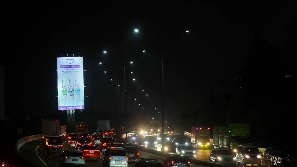 Illuminated Lebak Bulus billboard at night above heavy traffic on Jl. RA Kartini, South Jakarta