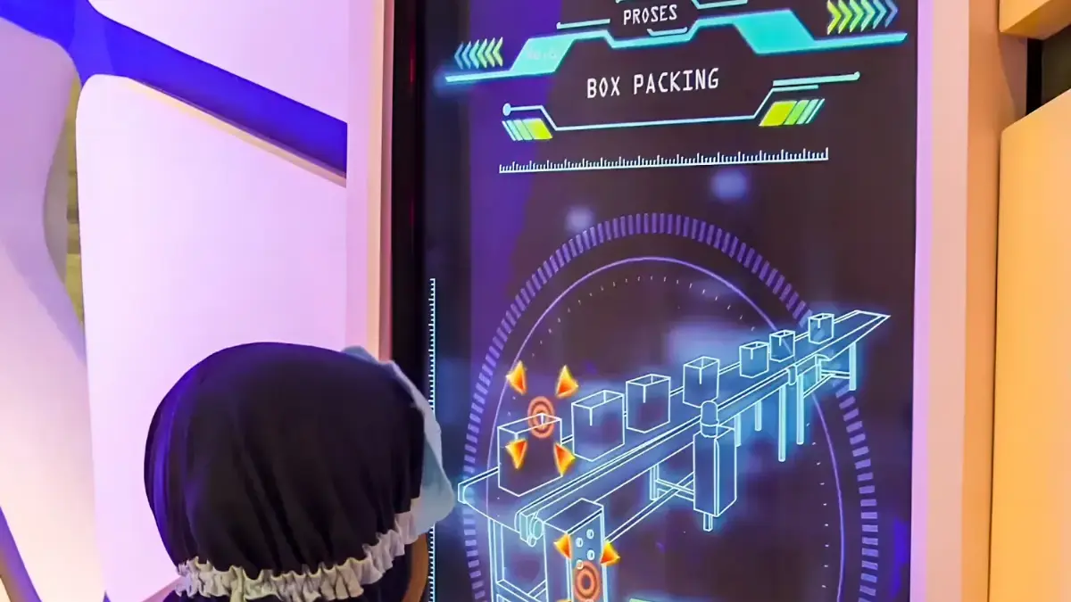 Child playing a Chocolatos portrait touchscreen game showing a box-packing process at a Garudafood activation