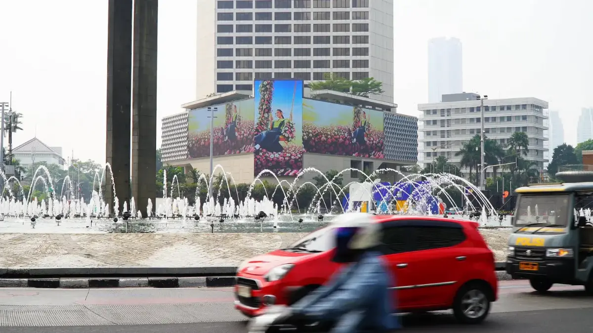Three-sided robotic LED on the Mandarin Oriental Hotel at Bundaran HI showing one visual split across an upright centre face and two wide side faces