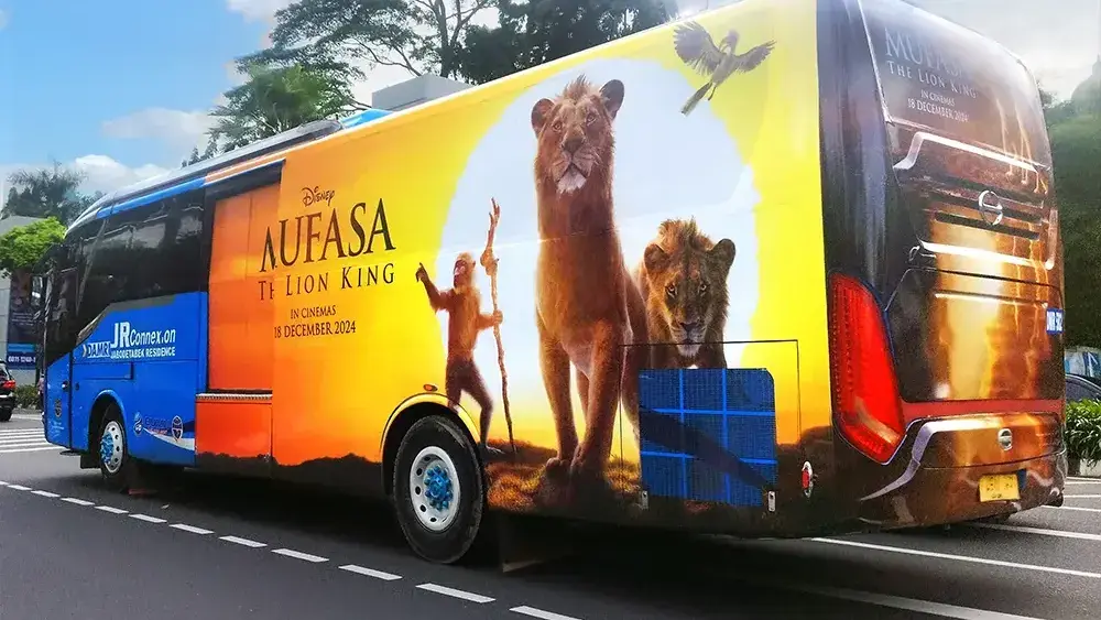 Transjabodetabek bus wrapped with Disney's Mufasa film artwork showing the cinema release date