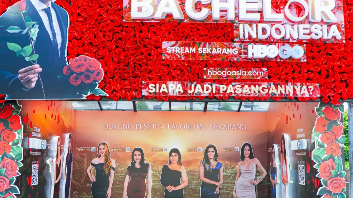 Bus shelter with creative branding for HBO GO's The Bachelor Indonesia, decorated with a red rose wall and themed benches