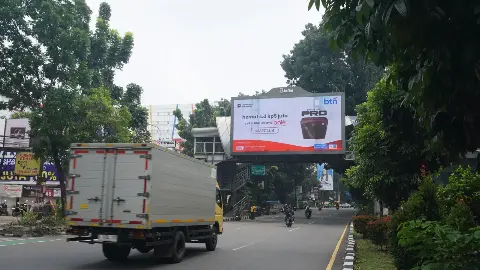 LED videotron 8infini di jembatan penyeberangan kawasan Masjid Raya Bogor, dengan truk dan sepeda motor melintas di jalan berpohon