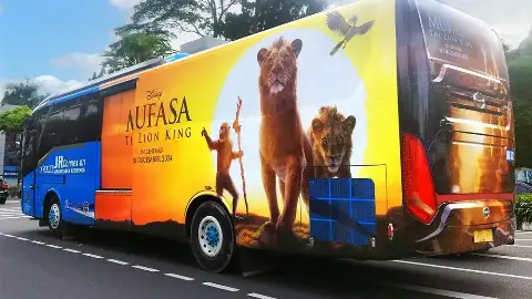 Transjabodetabek bus wrapped with Disney's Mufasa film artwork showing the cinema release date